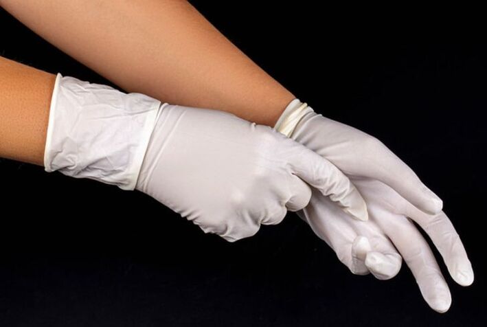 Hands putting on white medical gloves